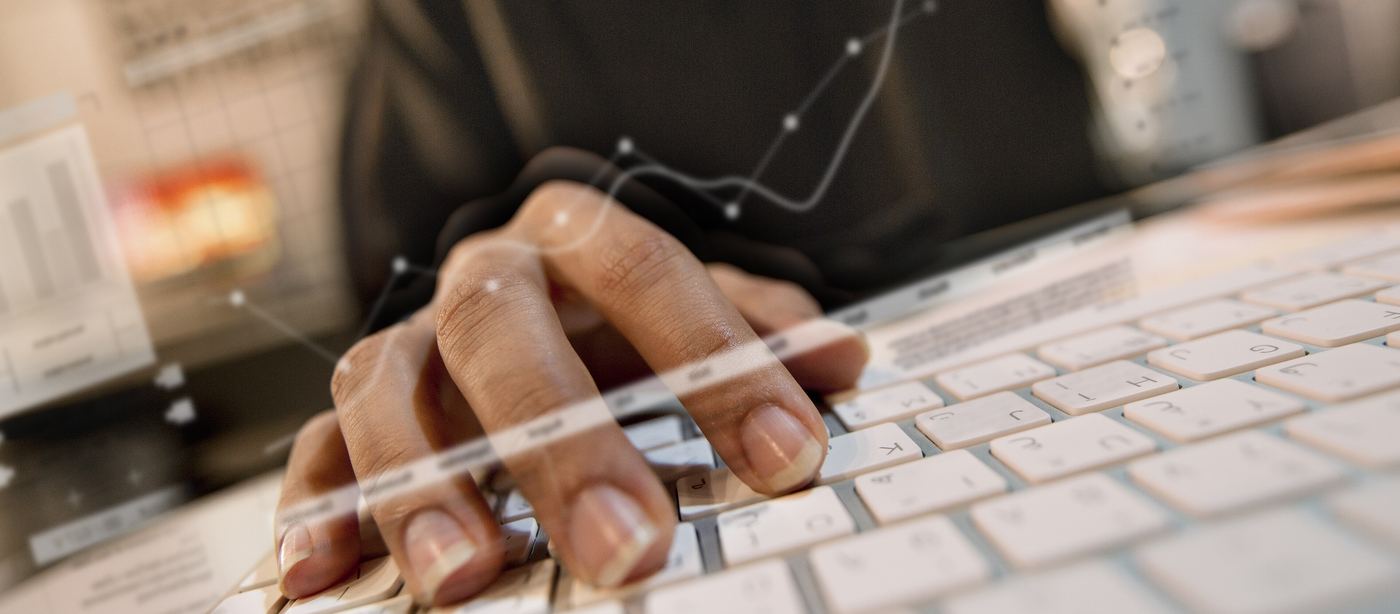Hands typing on a keyboard with data overlays