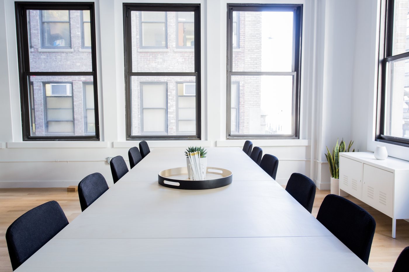Meeting room with a long white table and dark chairs